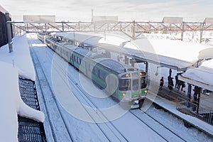 Train stop at railway station with snow of winter in Japan.