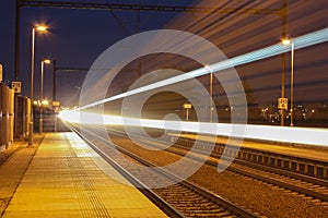 Train with strong light on long exposure in station at night scene.