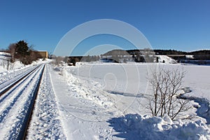 A train track cleared of snow after a record breaking snowfall in the Maritimes of Canada on a clear winter day