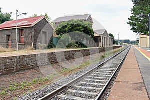 train tracks and a bluestone railway station buildings and platform