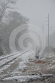 The Train tracks covered in snow during a snowstorm