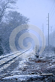 The Train tracks covered in snow during a snowstorm
