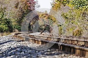 Train tracks disappearing into a rural autumn landscape