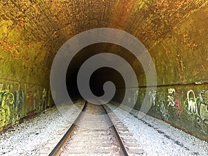 Train Tracks and Graffiti Inside a Dark Tunnel