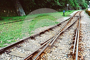 Train tracks on gravel, two of railways tracks merge in a rural scene background, concept of journey