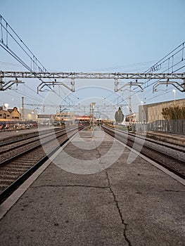 Train tracks with high power electricity cables and old concrete platform