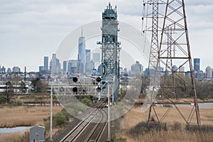 Train tracks lead into the New York New Jersey waterfront on a cloudy day showing urban sprawl and industrial areas