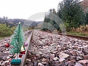 Train tracks near Christmas tree photo