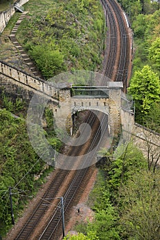 Train tracks passing under old ruins