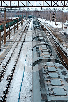 A train on the trainstation duing a winter and one rail is empty