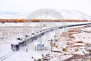 Train transporting tank cars. Season changing autumn to winter.