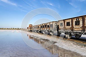 train travels from water. Mined salt in Lake Burlin. Altai. Russia. Bursolith. Old train rides on the railway laid in the water