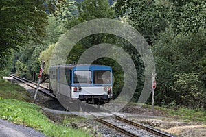 A train with two wagons passing through a train crossing