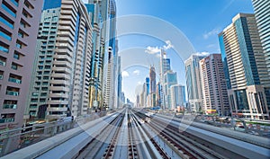 Train view on railway in Dubai Downtown at financial district, skyscraper buildings in urban city, UAE. Transportation for
