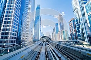 Train view on railway in Dubai Downtown at financial district, skyscraper buildings in urban city, UAE. Transportation for