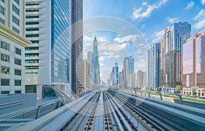 Train view on railway in Dubai Downtown at financial district, skyscraper buildings in urban city, UAE. Transportation for