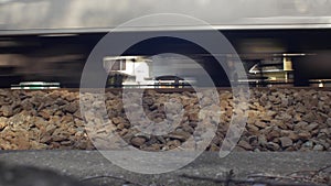 Train wheels passing by on gravel railway in front of houses