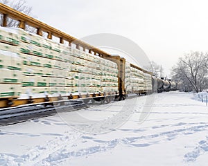 Train in winter speeds past on tracks