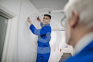 Trainee Electrician Fitting a Security Camera