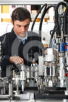 Trainee Engineer Working On Machinery In Factory