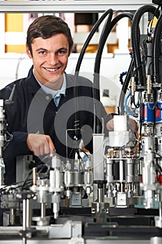 Trainee Engineer Working On Machinery In Factory