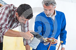 Trainee learning to solder in workshop