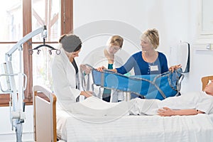 Trainee nurses looking at aid for moving patient
