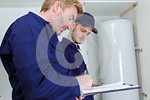 trainee plumber working on central heating boiler