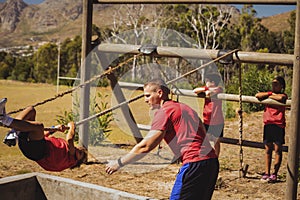 Trainer assisting a boy in obstacle course training