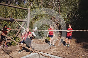 Trainer assisting a boy in obstacle course training