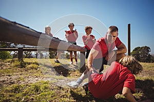 Trainer assisting kids in the obstacle course training