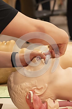 A trainer demonstrate how to place oral airway on a CPR model.