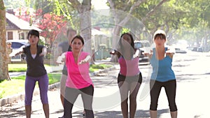 Trainer Encouraging Group As They Exercise