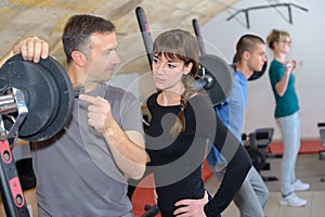 Trainer explaining how to use training machine in gym