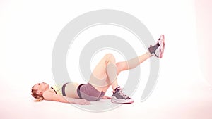 Trainer fitness girl doing glut bridge with leg rise frontal view. Sports video tutorials isolated on white. Health care
