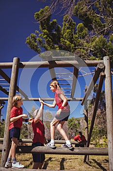 Trainer and girl giving high five to each other during obstacle course training