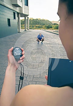 Trainer hand using chronometer to timing man