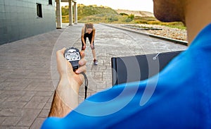 Trainer hand using chronometer to timing woman