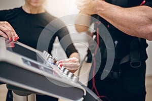 Trainer hands turning on ems device