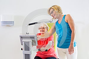 Trainer helping patient with exercise machine