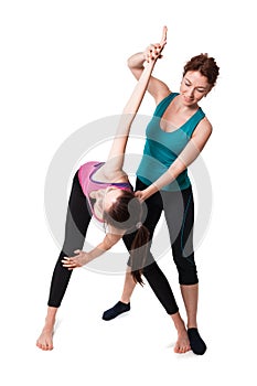 Trainer helping woman with positioning on her yoga pose.