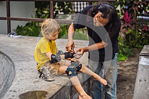 Trainer helps the boy to wear knee pads and armbands before training skate board