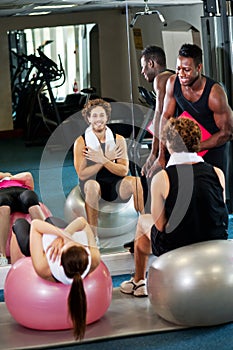 Trainer instructing gym clients photo