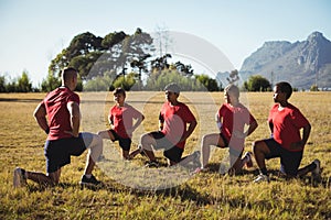 Trainer instructing kids while exercising in the boot camp