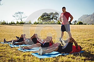 Trainer instructing kids while exercising in the boot camp