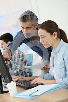 Trainer with interns working on computer