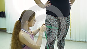 Trainer Measuring Leg Size of her Client