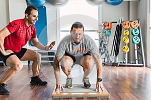 Trainer motivating a man exercising indoors