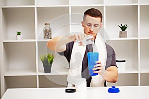 Trainer prepares a protein shake in the shaker after training.