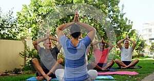 Trainer and seniors performing yoga in garden 4k